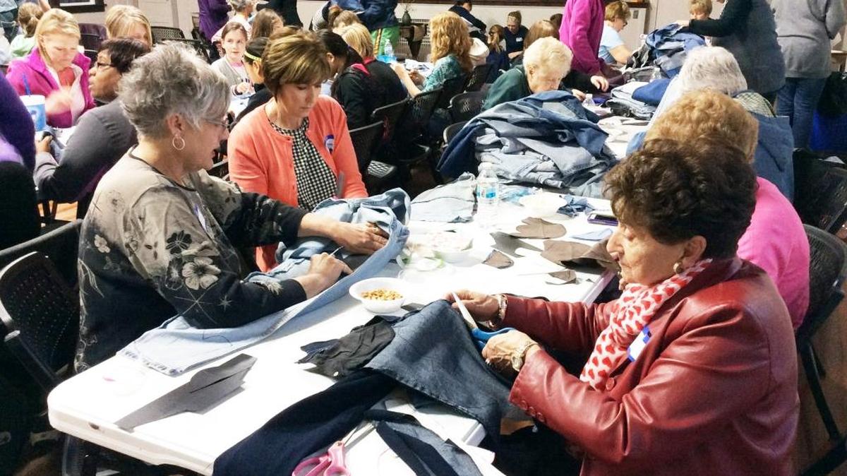 Women4given members and volunteers gathered recently to help turn used denim into fabric for shoes that will be made in Uganda and distributed to children there.