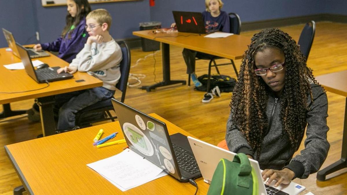 Chasity Pedersen installs Notepad ++ on a computer at the start of a web design class at the Junior Code Academy.
