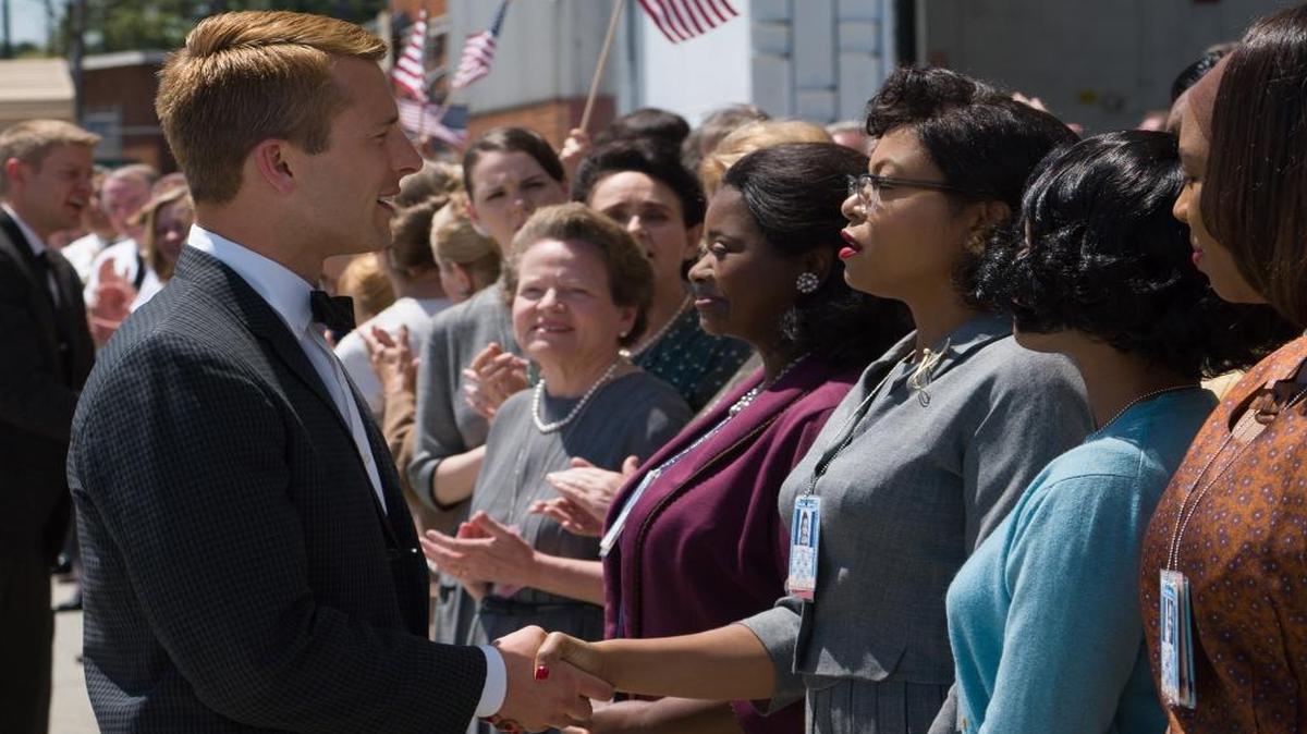 Katherine Johnson (Taraji P. Henson) shakes hands with John Glenn, played by Glenn Powell. On her left is Octavia Spencer, who portrays Dorothy Vaughn. Both, along with Mary Jackson (Janel Monee, in blue) portray three mathematicians who worked at NASA in the 1960s. Their story is told in “Hidden Figures.”