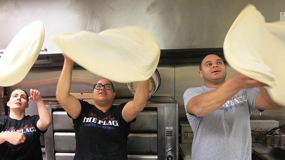 Flipping pizzas at Flamentco’s The Place American Eatery are, from left: Brittany, Bianca and Cory Flament. Brittany and Cory are husband and wife, and Bianca is Cory’s sister. Brittany is CEO of the pizza eatery, Cory is president of operations and marketing and Bianca is vice president.