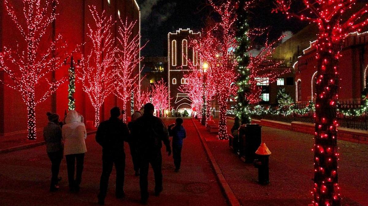 Pestalozzi Street is lined with trees full of red lights and street lamps with greenery and white lights at Anheuser-Busch Brewery in St. Louis around Christmastime.