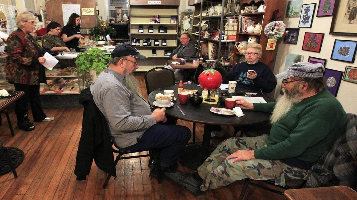 Maggie Boone Tribout (standing at left) is a co-host of the "Death Cafe" meetings, which are held in Belleville at the Miscellanea House coffehouse. Here, she speaks to those gathered to discuss death and dying in an informal setting. Eating cake during the discussions is one of the traditional prerequisites.