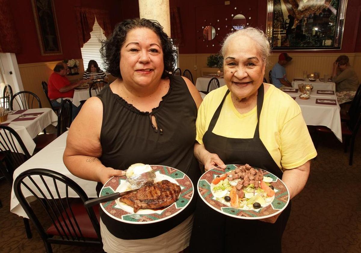 Owners Lani Parker, left, and her mother, Silulu Brown, hold a ribeye steak and Black and Blue salad at Valentine’s in Freeburg in 2017. The restaurant has been in the family for nearly 44 years.