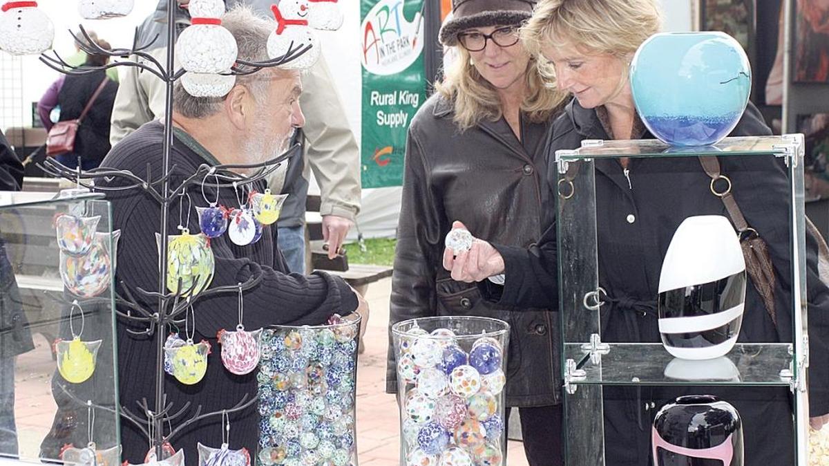 
Barb Shoemaker and Donna Picket talk with glass artist Reinhard Herzog at last year’s Art in the Park.
