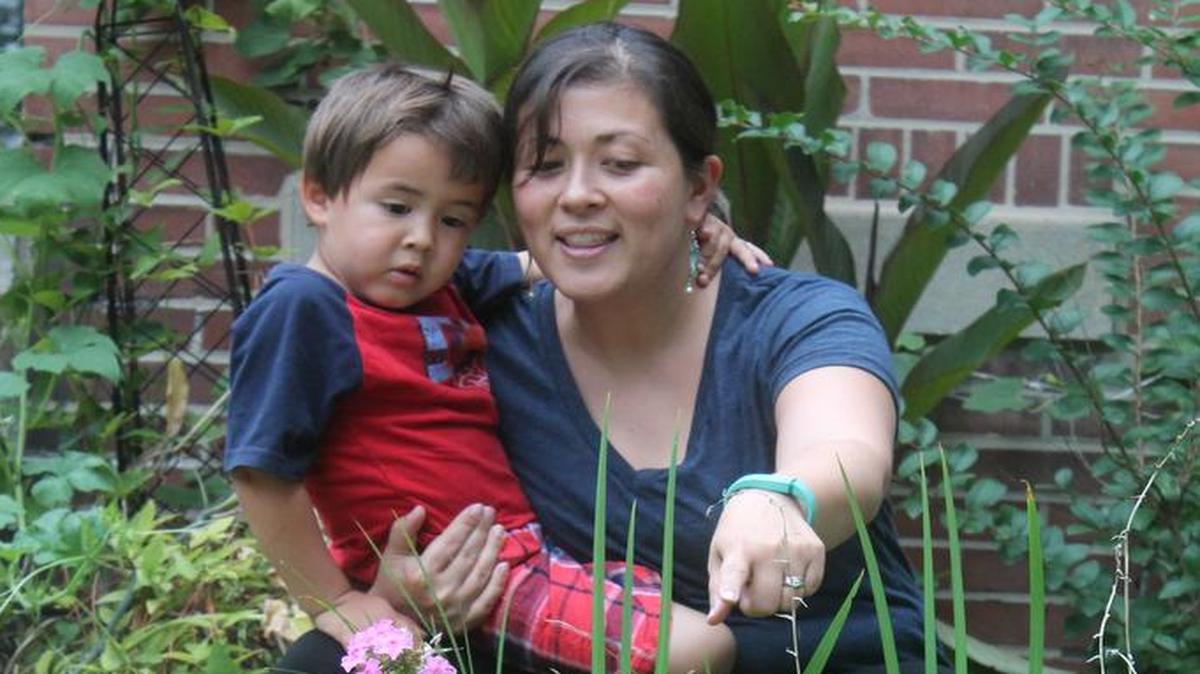 
Mara Higdon and son Walt, 3, look over what’s growing in their front yard garden in south St. Louis.
