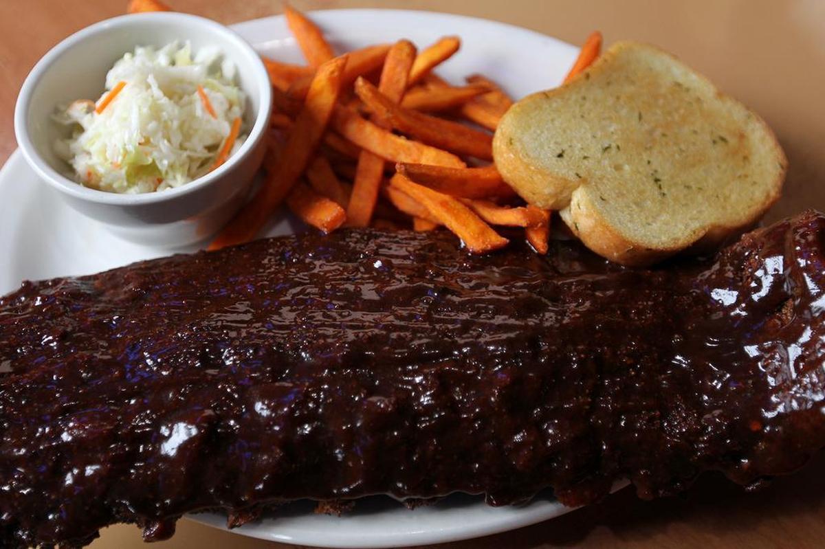 A full order of ribs, cole slaw and sweet potato fries at JV’s Bar & Grill in Waterloo.