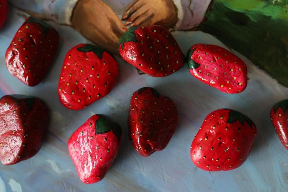 Jeff Harris painted these strawberry rocks. Several Facebook groups in the area are home to loose associations of painters and hiders and those who seek the rocks. Painted rocks are hidden in plain sight – on top of a fence, in the crook of a tree, tucked into a flowerpot – and patiently wait for a keen set of eyes.