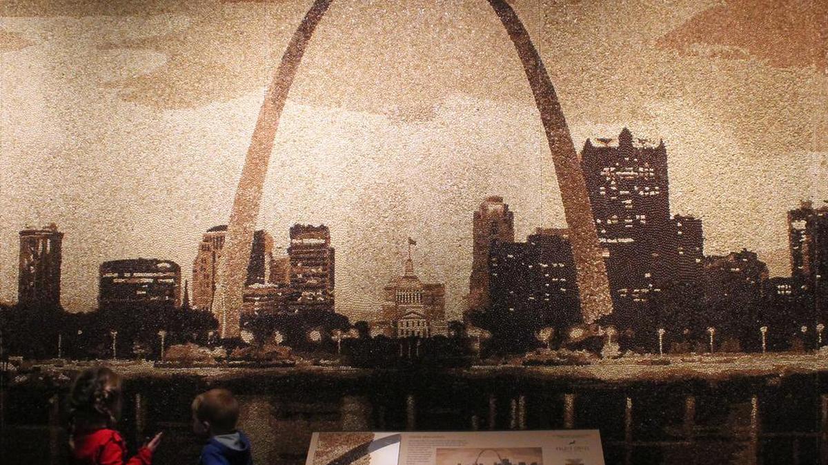 What gives this image of the Gateway Arch its brown tone? The 260,000 coffee beans it is made of. The creation is part of “Coffee: The World in Your Cup & St. Louis in Your Cup” at Missouri History Museum.