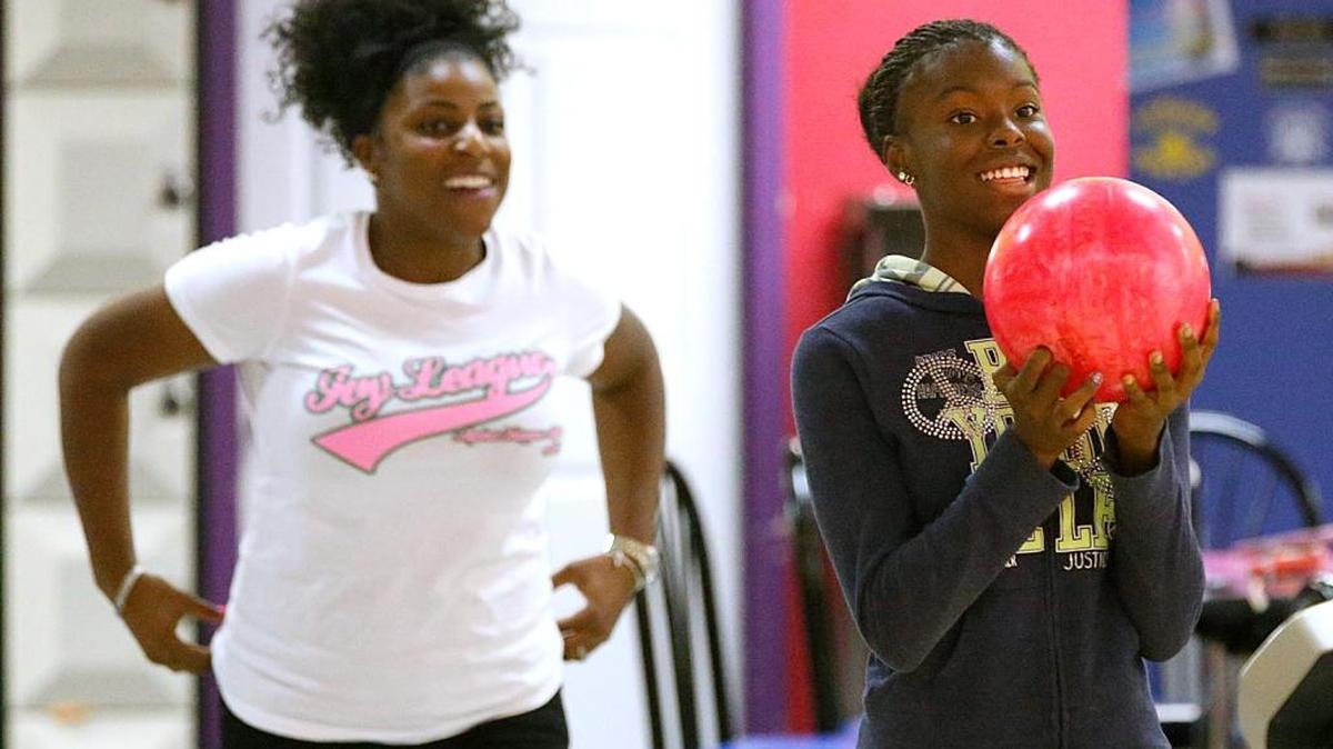 
JaRiah Taylor,13, of East St. Louis, right, gets ready to roll her ball as big sister Charrell Barksdale, 28, of Belleville, watches at St. Clair Bowl in Fairview Heights.
