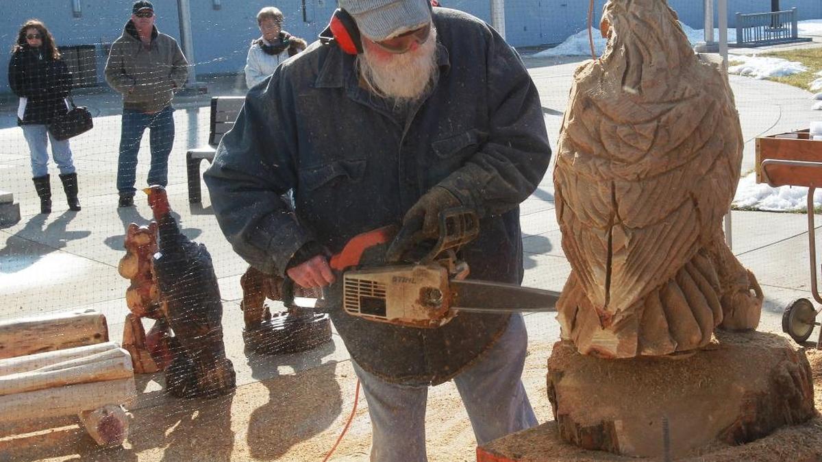 Luke Harris, of Alton, half of the Itchy Brothers Chainsaw Art team puts finishing touches on a life-size eagle he carved out of a block of sassafras wood in this 2014 photo.