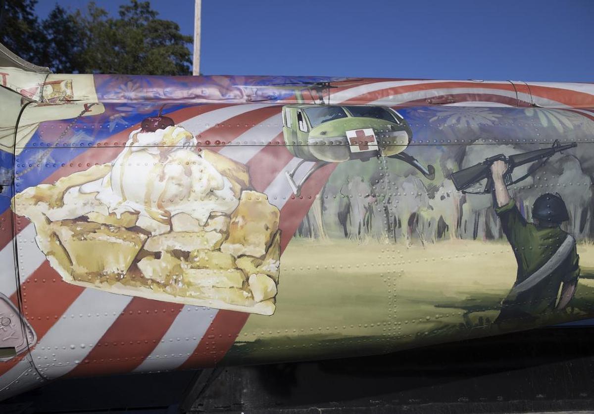 A detail photo of “Take Me Home Huey,” a mixed-media sculpture made out of a U.S. Army helicopter that served as an air ambulance in the Vietnam War. Artist Steve Maloney covered it with images of Mom’s apple pie and other things soldiers may have dreamed about while stationed overseas.