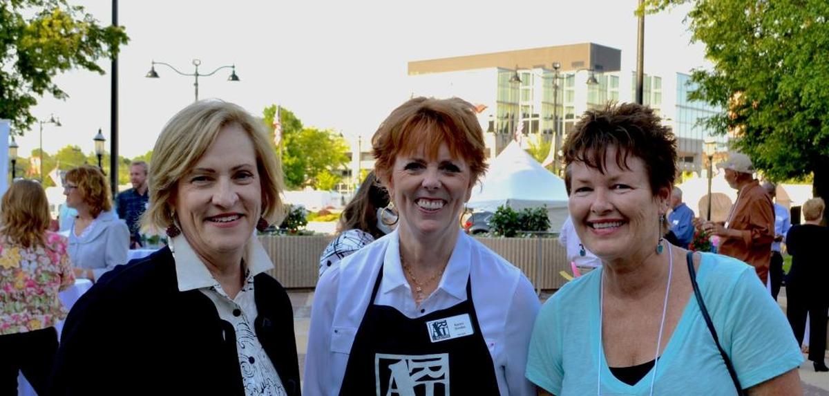 Volunteers Julie Harvey, left, and Karen Strobo with artist Katherine Kaya at a previous Art on the Square.