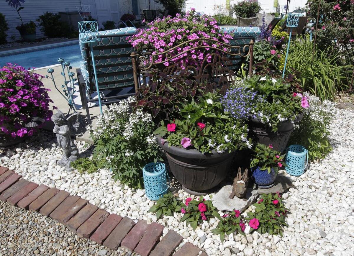 Planters and interesting combinations of foliage and flowers — showing a variety of textures and colors — in the backyard of Eric McConachie and Heather Stolte-McConachie of Collinsville.