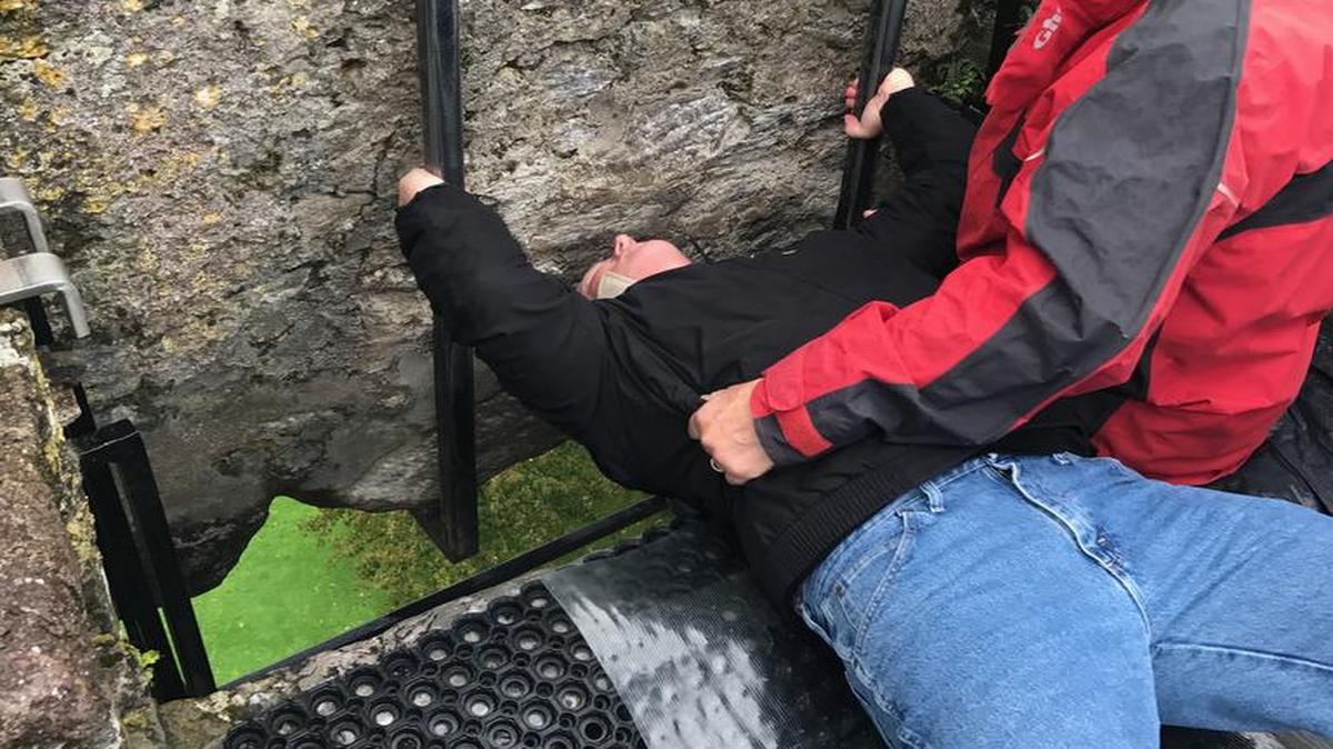 Terry Mackin kissing the Blarney Stone in Ireland.