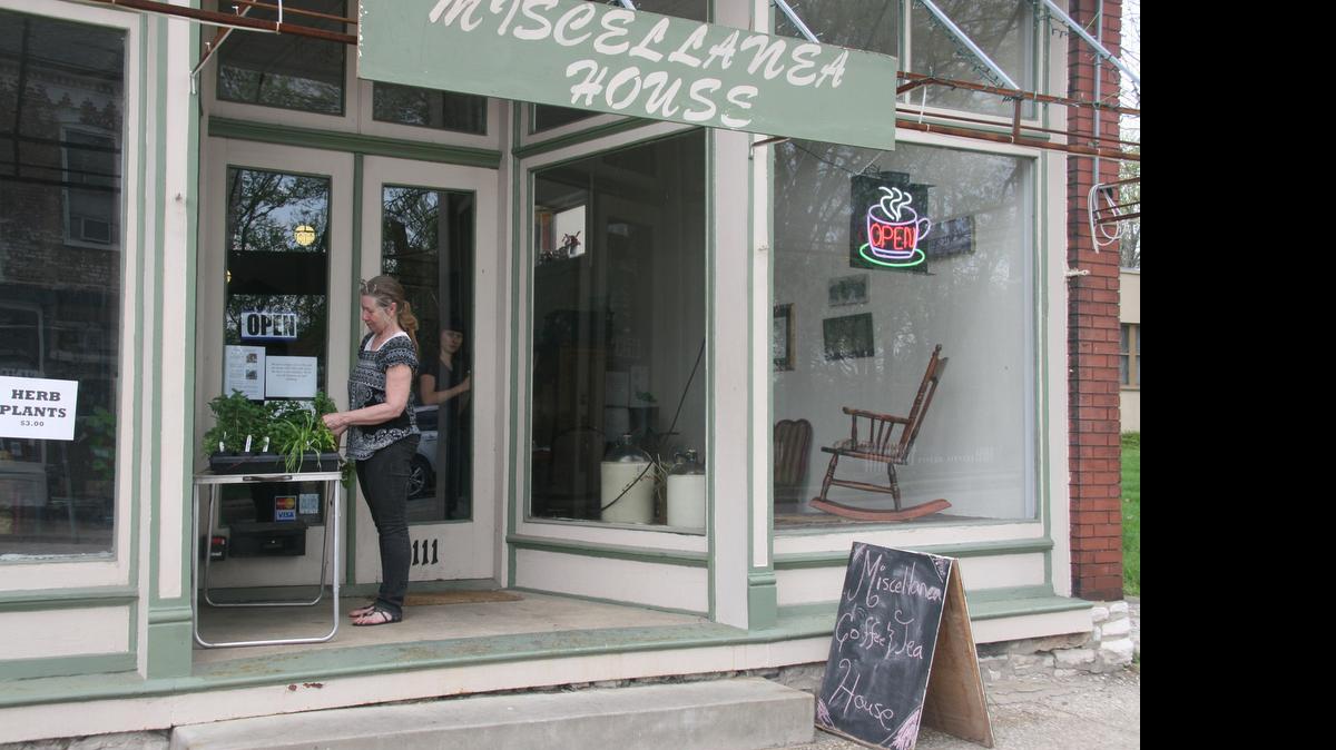 
Sharon Egler, co-owner of Miscellenea House, tends to herb plants she sells at the coffee house cafe at 1111 W. Main St. The 1907 brick storefront originally housed a dentist office. 

