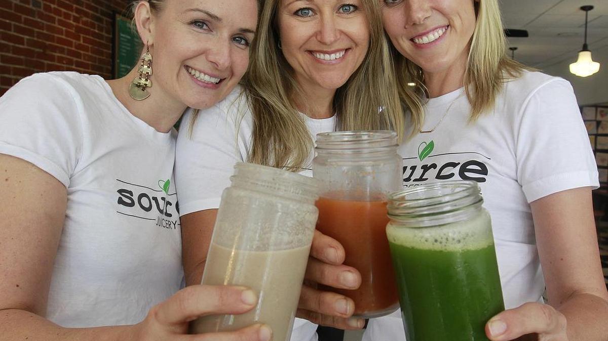 The three co-owners of the Source Juicery are (from left) Lisa Hudson, Chrissy Stevens, and Michelle Motley, shown making a toast to the success of their downtown Edwardsville business.