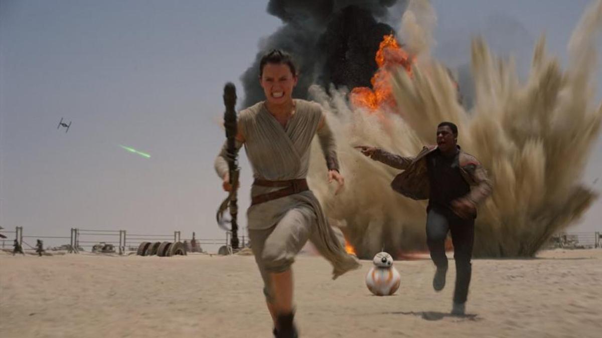 —Daisy Ridley and John Boyega are on the run in “Star Wars: Episode VII —The Force Awakens.”