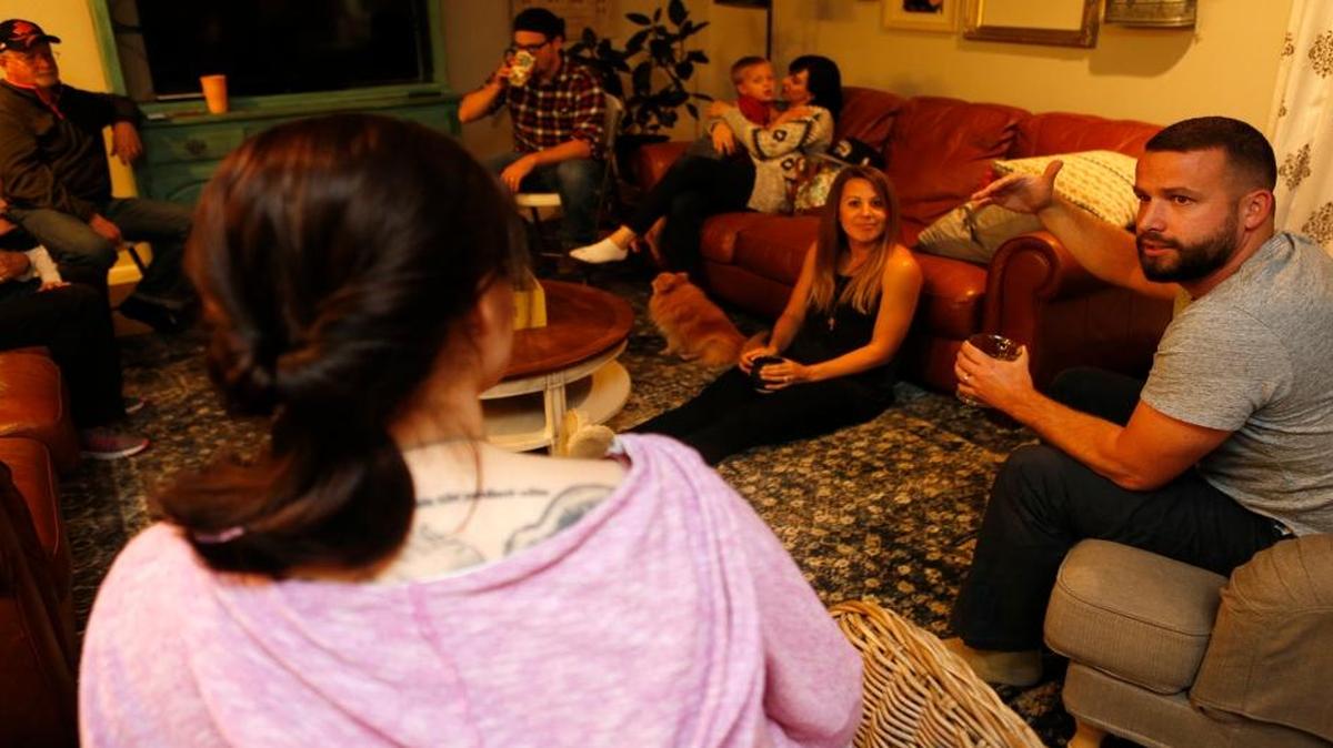 Michael Collins leads a discussion during a meeting of Mercy’s Door Community Church at the home he shares in Mascoutah with his wife Rachael, right, on floor, and their four children. The church will hold an open house Friday at its permanent home, 9 S. Jefferson St.