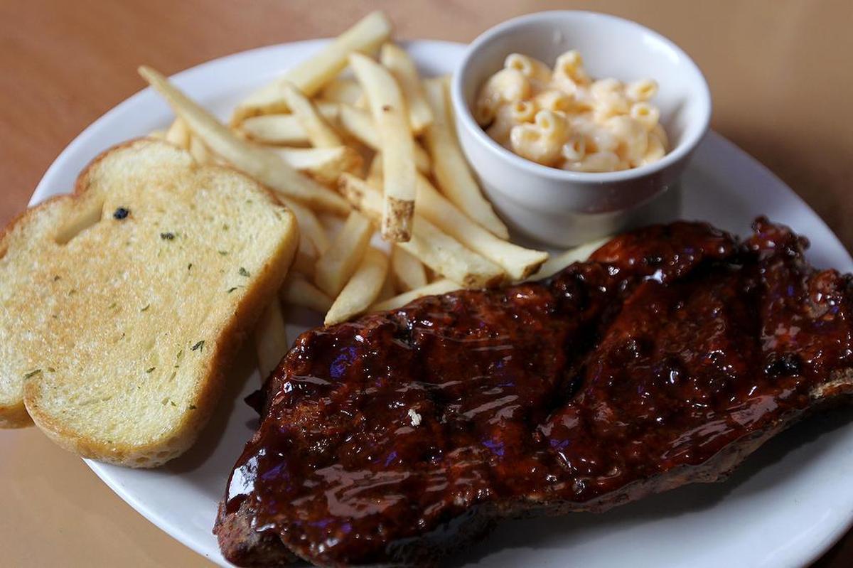 A pork steak with fries and mac'n cheese at JV’s Bar & Grill in Waterloo.