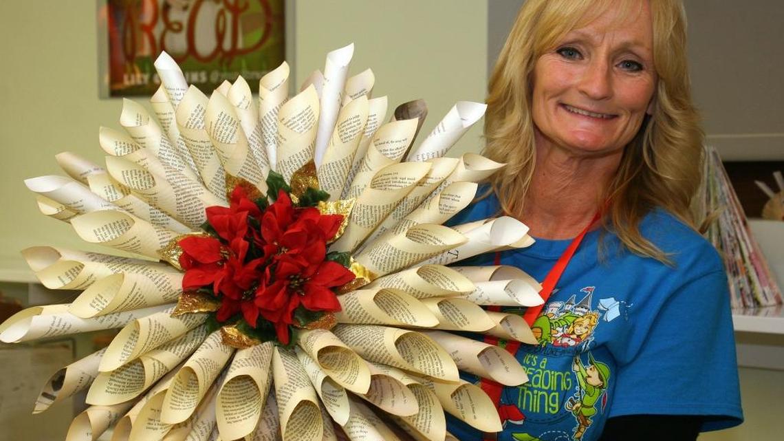 Rhonda LeMaster created this Christmas wreath from pages of a book no longer on the shelves of the downtown library in Granite City . “It's an addicting thing,” said Rhonda, youth services assistant.