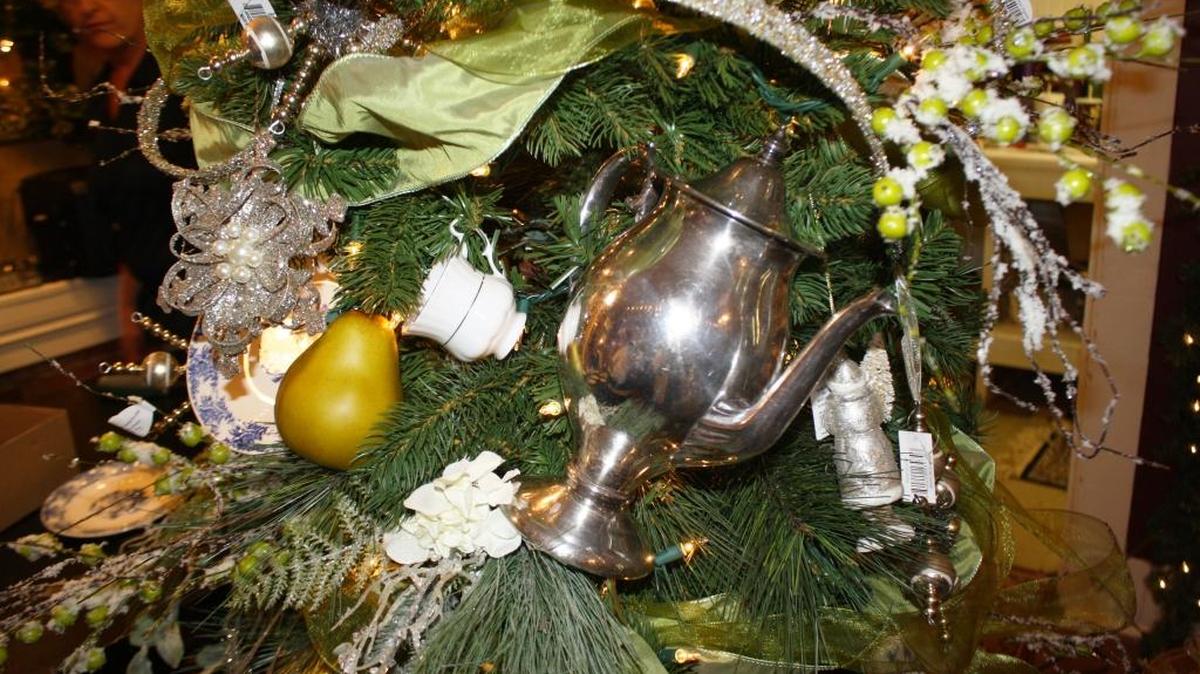 Dawn said she bought the vintage silver teapot for $3 and uses it as a prop in her house year-round, as well as annually as a Christmas decoration. She attached wire to it and hung it in the lower center part of the tree, explaining that heavier items should be placed near the bottom for weight and balance.