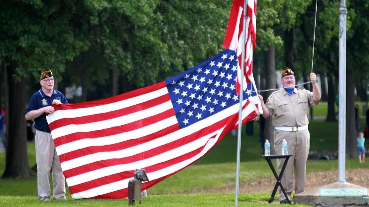 Veterans raised flags at a previous Belleville Memorial Day ceremony at Walnut Hill cemetery.