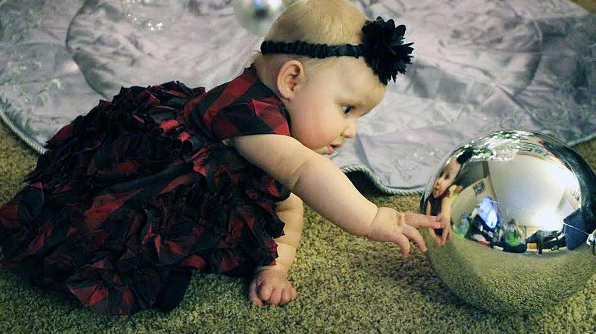 Blake Biver, 5 1/2-month-old daughter of Bob and Melanie Biver, checks out an ornament that’s almost as big as she is. The family lives in Fairview Heights.