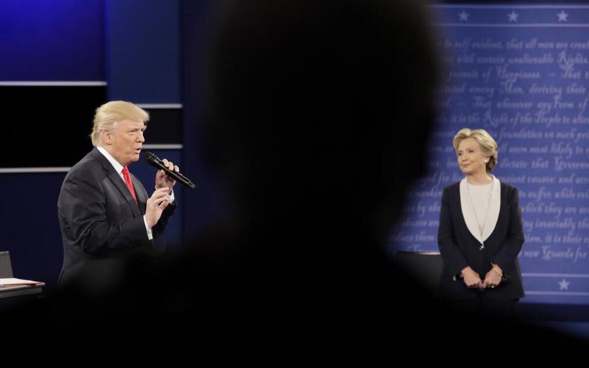 Bill Clinton, in foreground, watches the second presidential debate between Democratic presidential nominee Hillary Clinton and Republican presidential nominee Donald Trump at Washington University, Sunday, Oct. 9, in St. Louis.