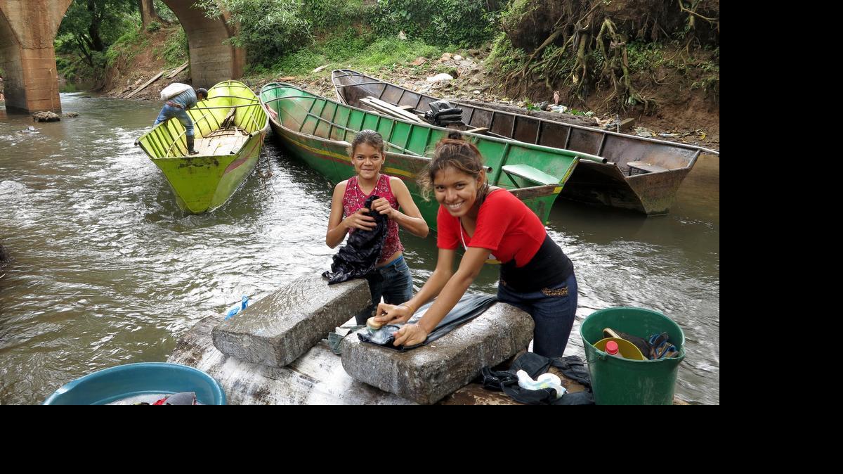 Two girls wash clothing in a small river in Puerto Principe, Nicaragua, on March 13, 2015. The town in eastern Nicaragua will likely be flooded to create an artificial lake crucial to a Chinese company's concession to build and operate a $50 billion cross-isthmus canal.
