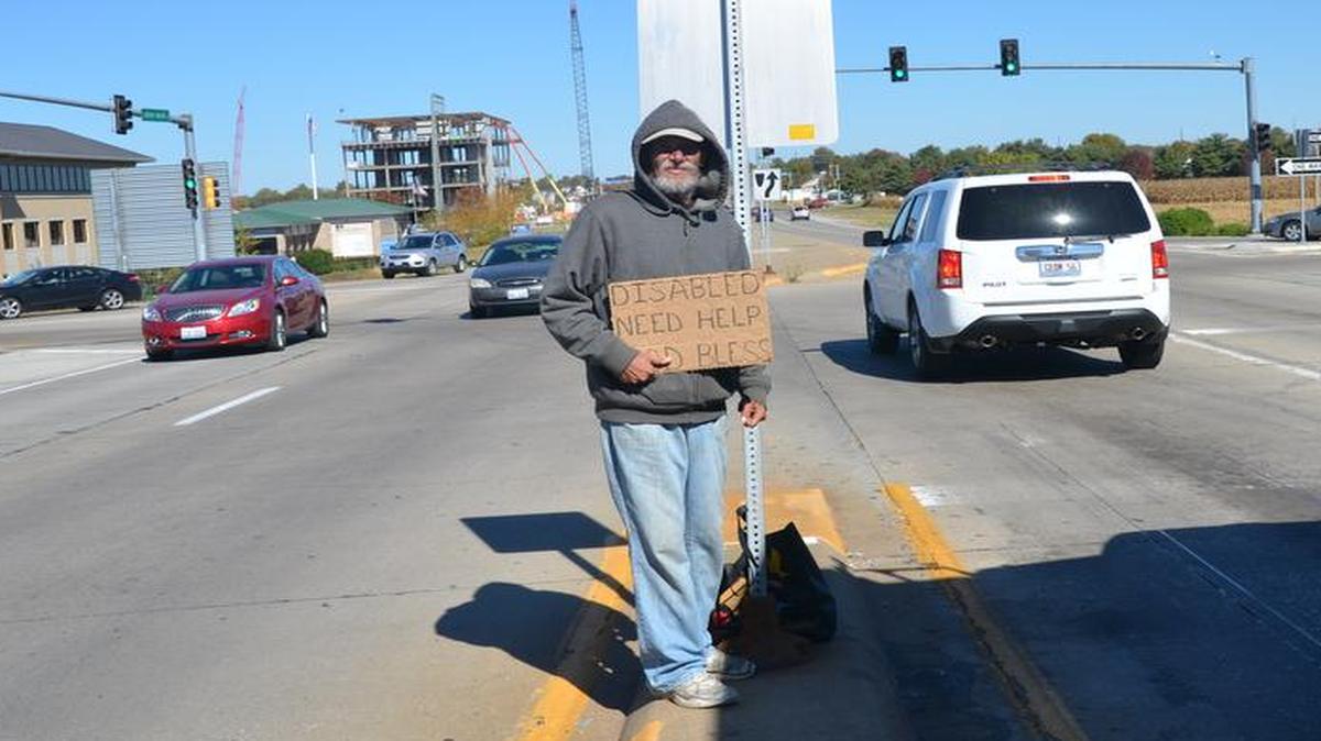 Michael Martin, 70, panhandles for money or food on the Green Mount Road, I-54 overpass in O’Fallon in October 2015.