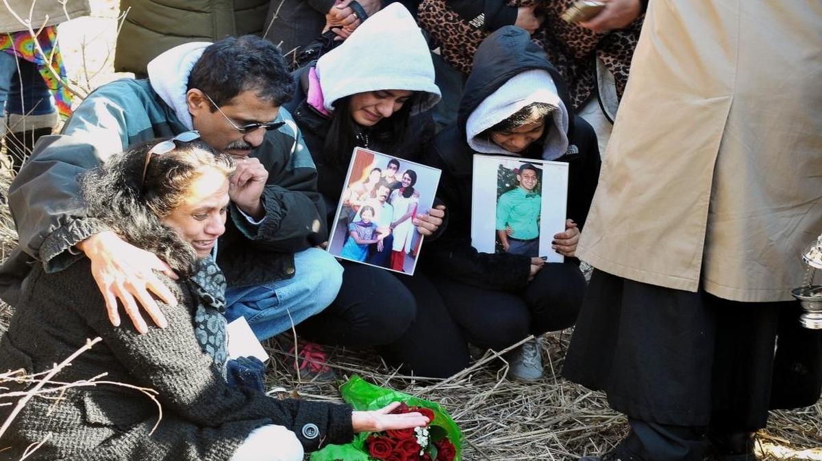 In this Feb. 13, 2015, photo, the family of 19-year-old Pravin Varughese — from left, his mother Lovely, father Matthew, and sisters Priya and Preethy — mourn at the scene of where his body was found a year ago in Carbondale. Gaege Bethune, 22, was charged Thursday, July 13, 2017, with two counts of first-degree murder in the case.