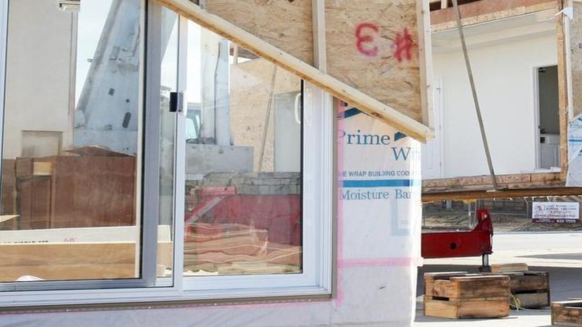 Workers assemble a custom pre-engineered home.