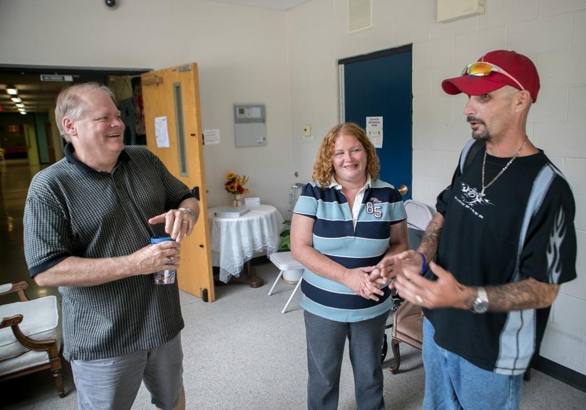 Cory Hartz, pastor of Trinity United Church of Christ, talks with Janie Medford and Dennis Dixon. Hartz has been helping the struggling couple.