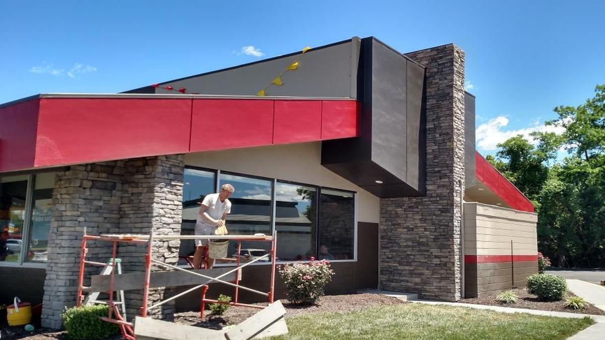 A worker puts finishing touches on the exterior of the Denny’s diner at 1130 S. Illinois St. in Belleville. The restaurant reopened May 26 following a renovation.