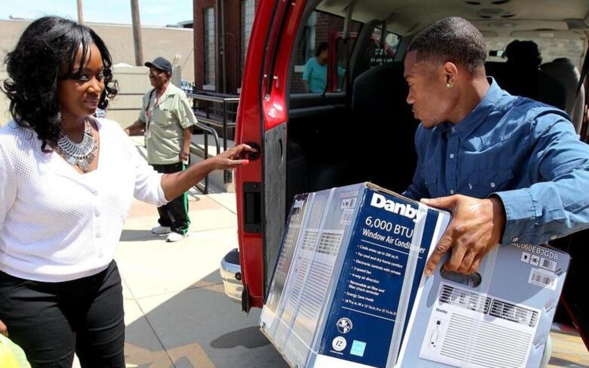 Ameren Illinois employee Stacey Young (left) and Stacy Minor help load portable air conditioning units donated by Ameren into a van of recipients in 2015 in Belleville.
