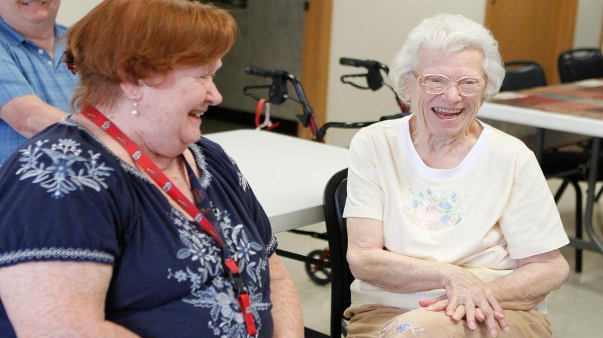 
From left: Clients Peggy Kachadorian and Jeanne Weinert share a laugh as they get ready to watch a movie at Golden Years Adult Day Care in Belleville.
