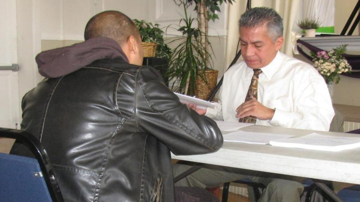 
Illinois Parole Board member Adam Monreal helps an attendee at a workshop on expungement of criminal records.
