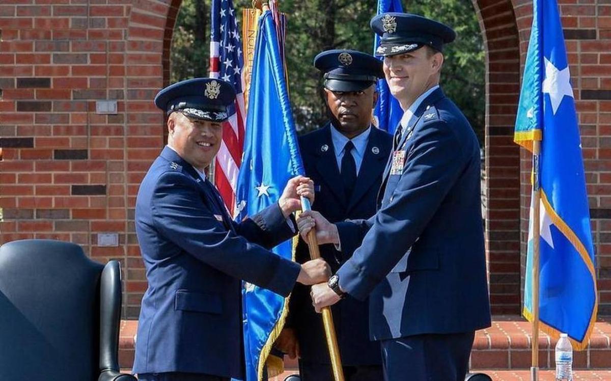 Lt. Gen. Giovanni Tuck, left, 18th Air Force commander, presents the 375th Air Mobility Wing guidon to Col. John Howard, signifying the start of his command of the wing during a change of command ceremony July 24 at Scott. Howard assumes command of the 375th AMW from Col. Laura Lenderman.