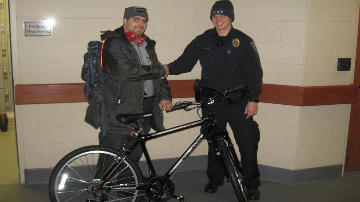 Nick Bonness, a local security guard, shakes hands with Fairview Heights police Officer Clay Mason. Mason donated a bike to Bonness, who was previously walking three hours to and from work.