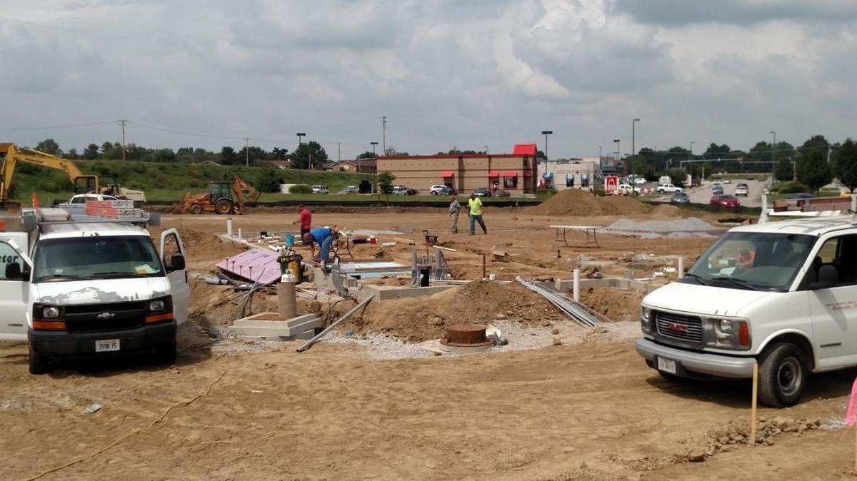 Workers prepare the site of what will be a St. Louis Bread Co. restaurant at Belleville Crossing. The restaurant occupies space between the Arby’s and Buffalo Wild Wings restaurants.