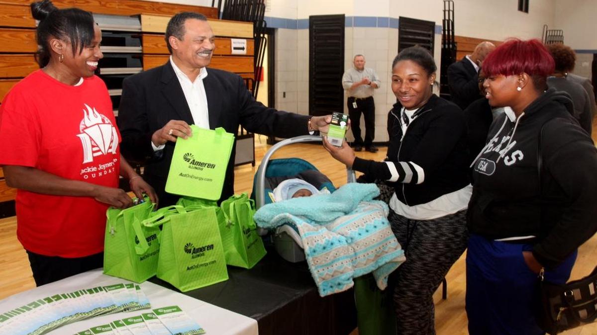 Jackie Joyner-Kersee, left, and Ameren Illinois President Richard Mark pass out goodie bags to residents.