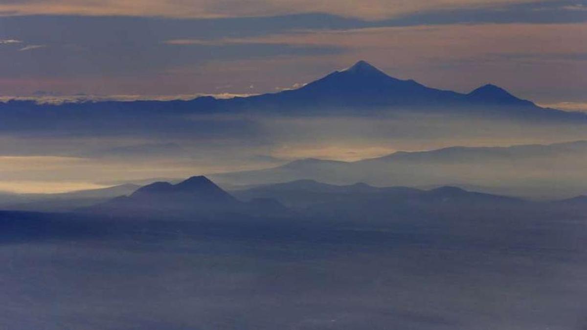 In this July 23, 2013 file photo, Mexico’s highest peak and the third highest in North America, Pico de Orizaba, or Citlaltepetl mountain, rises above the morning mist as seen from a Mexican Navy aircraft on a volcano monitoring mission in Mexico.