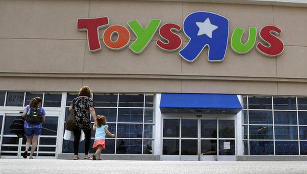 FILE - In this Sept. 19, 2017, file photo, shoppers walk into a Toys R Us store, in San Antonio. Toys R Us says it will be closing some U.S. stores and converting others to cobranded locations as it continues to deal with its financial restructuring following its bankruptcy filing.