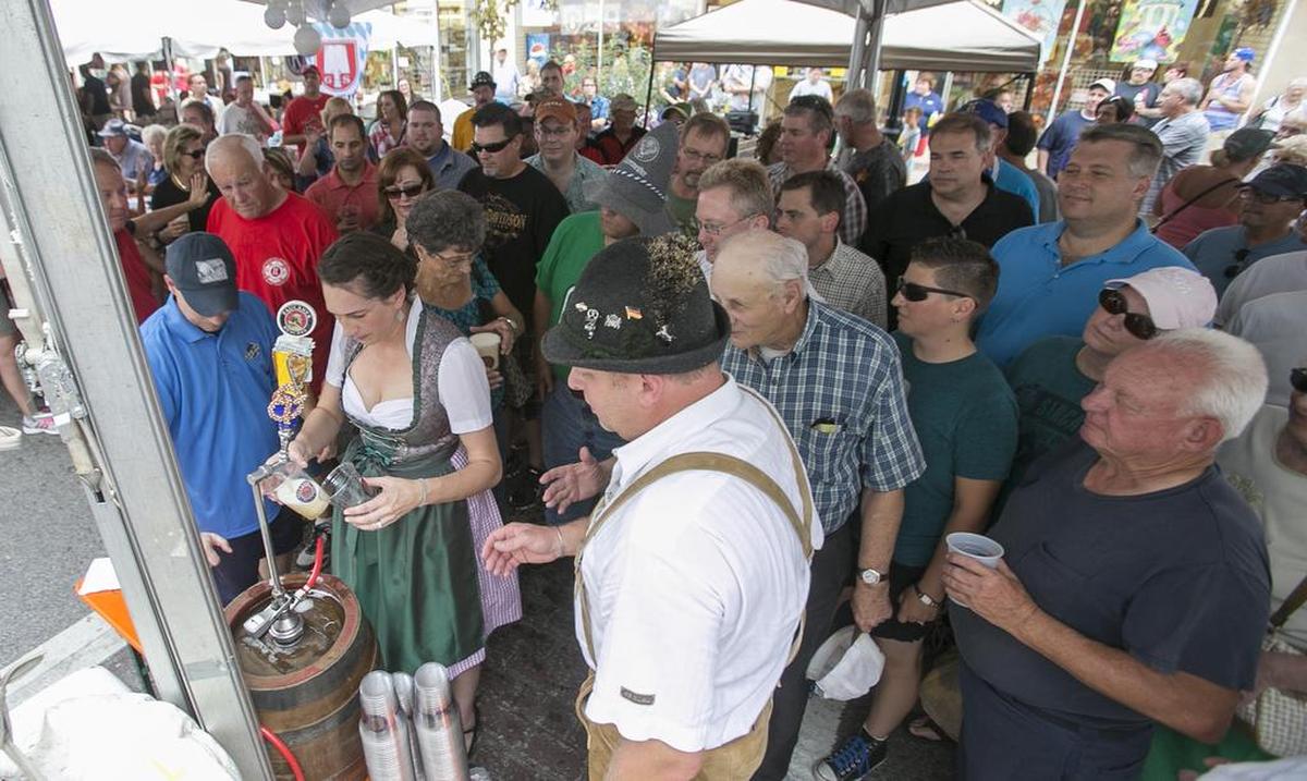 Ann Fritz-Bender and David Bender help distribute beer from the golden half keg of Stag beer to kick off Oktoberfest in 2015 in downtown Belleville. The tradition started in 1980.