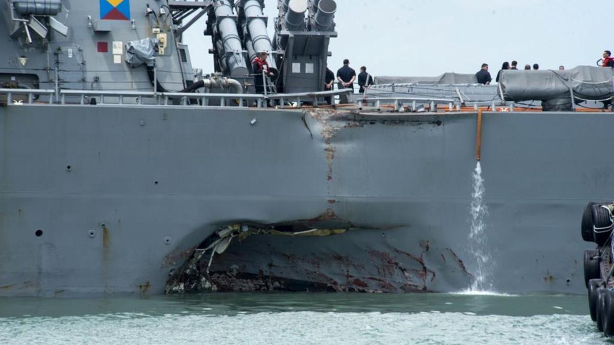 Damage to the portside is visible as the Guided-missile destroyer USS John S. McCain (DDG 56) steers towards Changi naval base in Singapore following a collision with the merchant vessel Alnic MC Monday, Aug. 21, 2017. The USS John S. McCain was docked at Singapore’s naval base with “significant damage” to its hull after an early morning collision with the Alnic MC as vessels from several nations searched Monday for missing U.S. sailors.