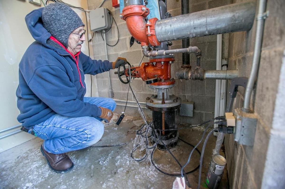 Plumber Jim Hutchings, with Embrich Plumbing Co. based in Maryville, looks for the source of a leak on a frozen water line that is part of a sprinkler system at a commercial business in Fairview Heights on Tuesday. A frozen meter appeared to be broken due to the extreme cold. The service area did not have heat turned on.
