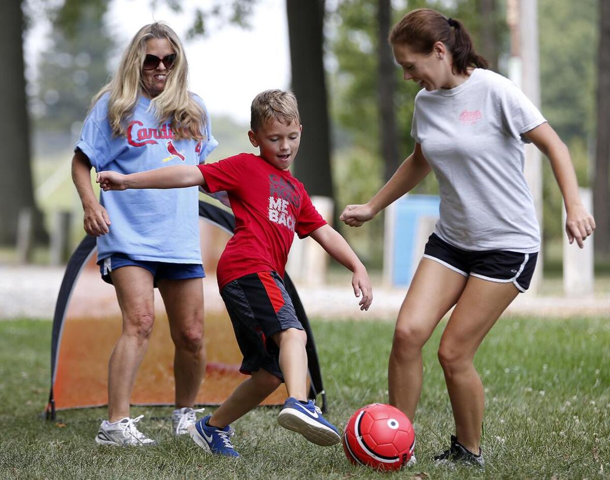 Nick Bunetic, 10, of Belleville kicks the ball around with his grandmother Mary Lou Mell (left) of Fairview Heights and mother Bobbi Bunetic Sunday at Laderman Park in Belleville.