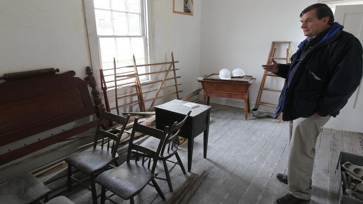 In this 2015 file photo, Bill Iseminger, chairman of Collinsville’s historic commission, inside the bedroom of the D.D. Collins House. The commission, which oversaw the home’s renovation, bought period furniture such as these chairs, small tables, and bed headboard to maintain historic authenticity.