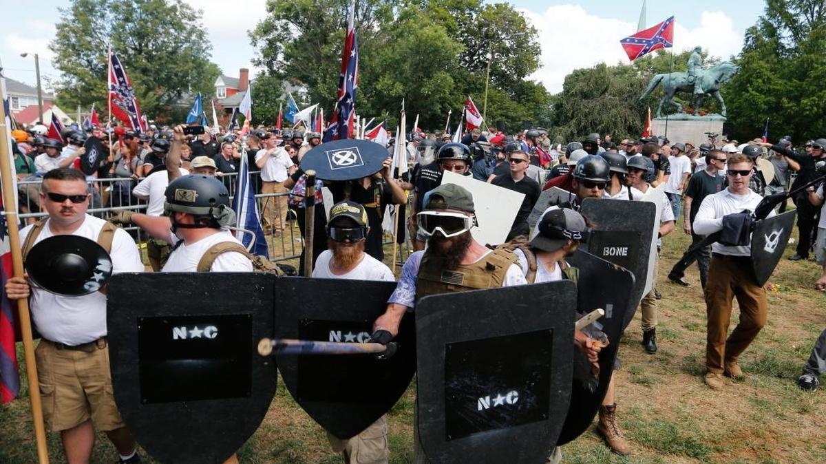 This Aug. 12, 2017, file photo shows white nationalist demonstrators holding their ground as they clash with counter demonstrators in Lee Park in Charlottesville, Va. Authorities have not provided a crowd estimate for the rally that descended into chaos. But two organizations that track hate groups and were monitoring the event said it was the largest white supremacist gathering in a decade or more.