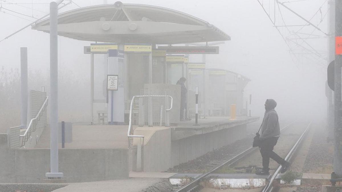 A man walks through the fog to the Metrolink train station Monday at the Southwestern Illinois College campus in Belleville.